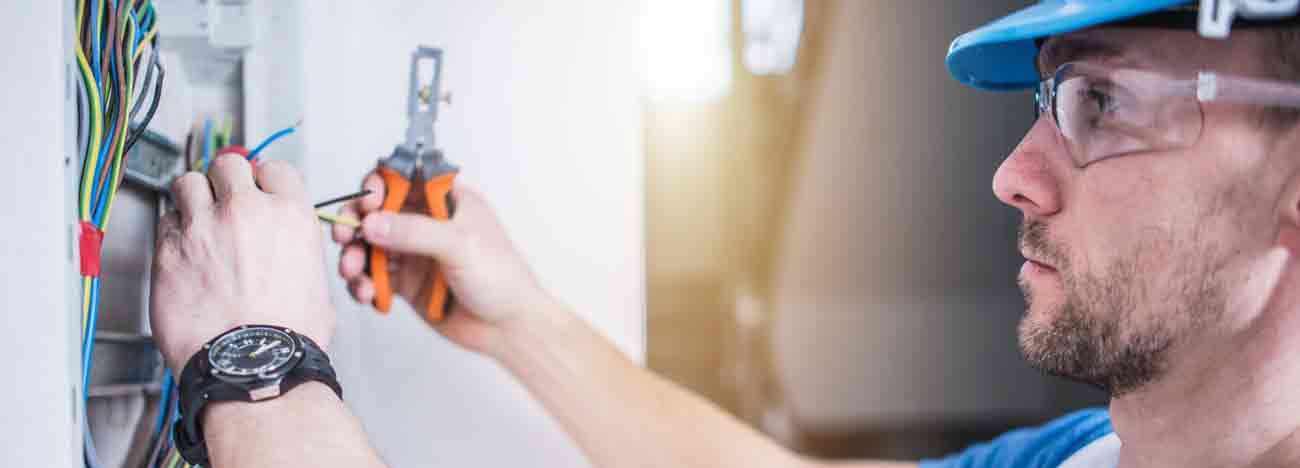 A contractor hanging replacing a light bulb.