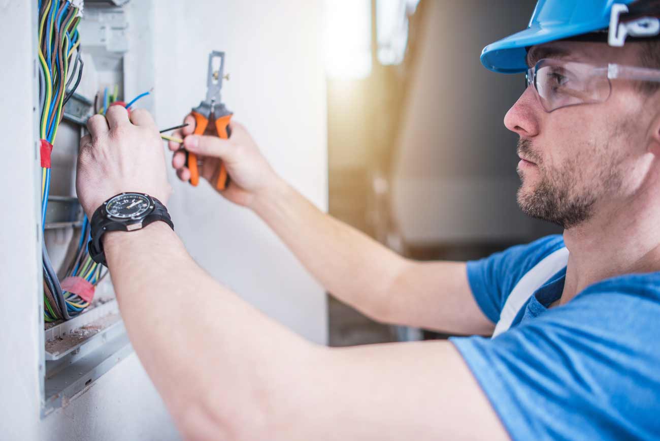 A contractor hanging replacing a light bulb.